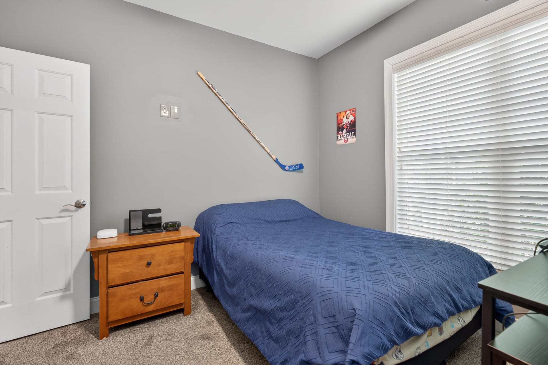 Bedroom with hockey stick and poster
