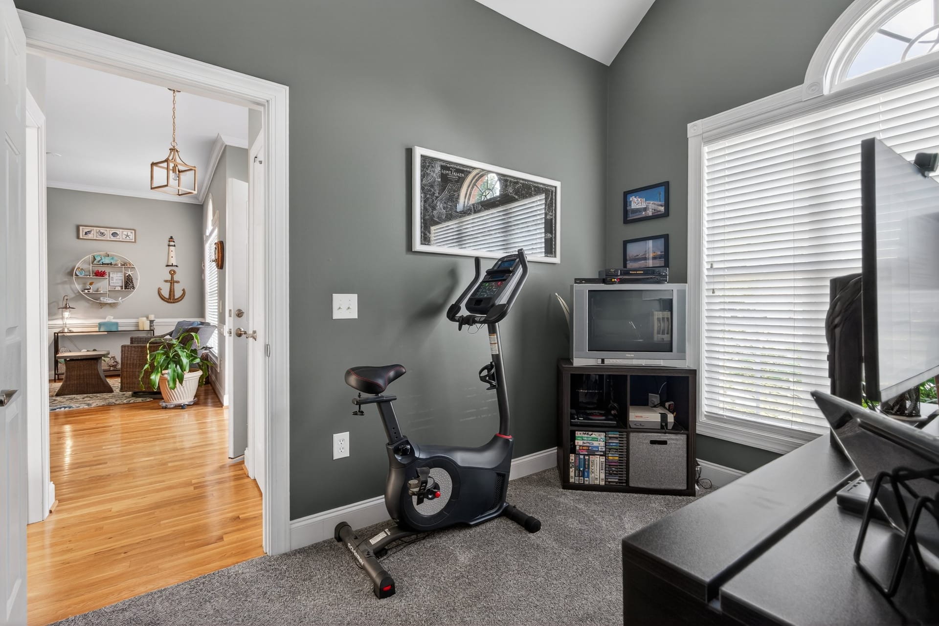Office with exercise bike and vaulted ceiling